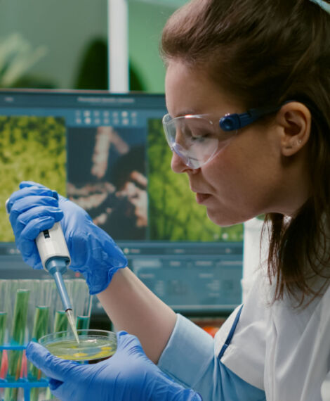 Chemist woman taking dna liquid from test tube with micropipette putting in petri dish analyzing genetic mutation. Biologist researcher working in pharmaceutical laboratory